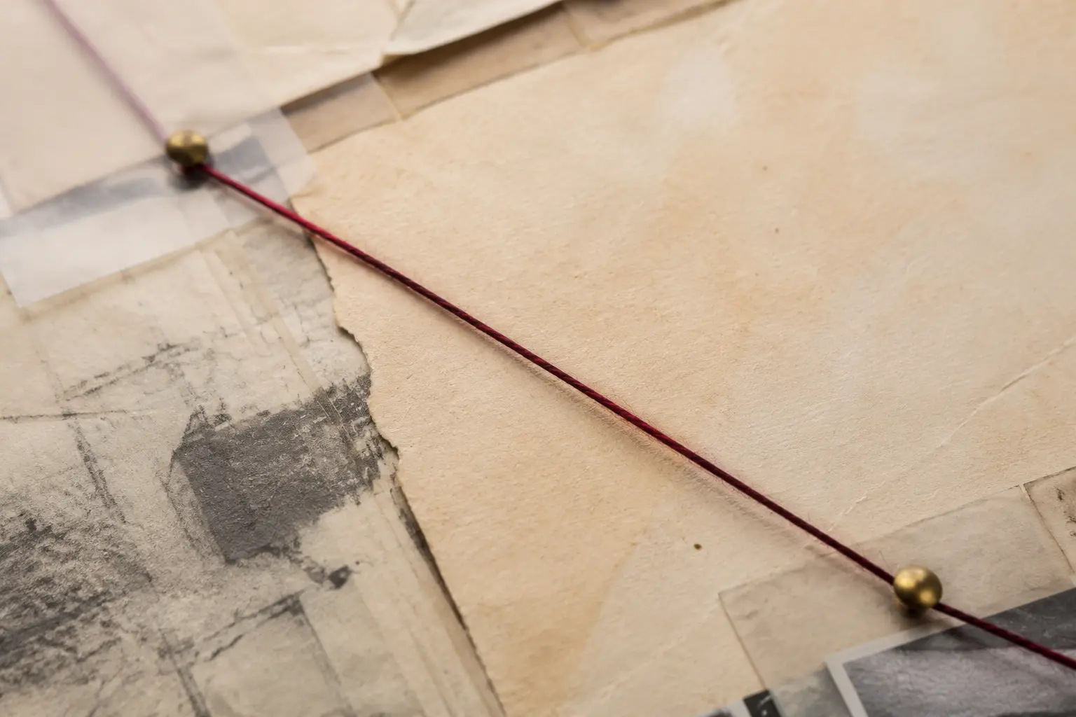 A restrained research wall connecting documents with a single red evidence thread